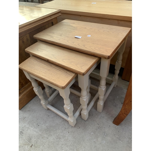 2533 - AN OAK NEST OF THREE TABLES ON PAINTED BASE WITH TURNED LEGS