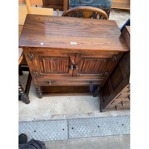 2588 - AN OAK JACOBEAN STYLE TWO DOOR CABINET WITH LINEN FOLD DOORS, SINGLE DRAWER ON OPEN BASE, 31