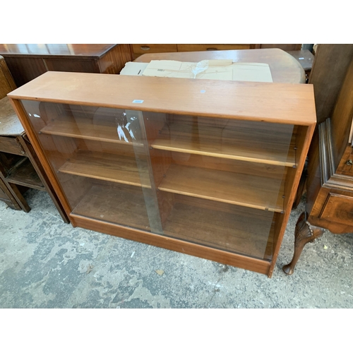 2664 - A RETRO TEAK BOOKCASE WITH TWO SLIDING GLASS DOORS, 48