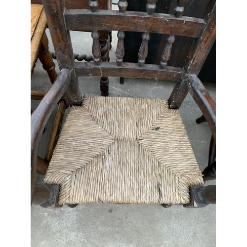 2669 - AN ELM AND BEECH CHILDS ARM CHAIR WITH TURNED SPINDLES AND RUSH SEAT