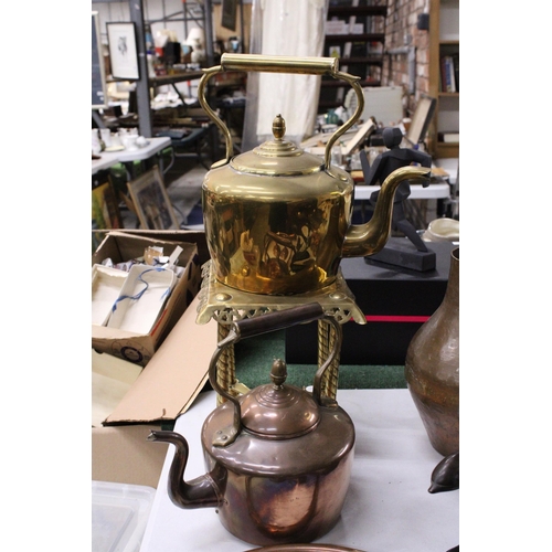 950 - A LARGE BRASS KETTLE ON A TRIVET PLUS A LARGE COPPER KETTLE BOTH WITH ACORN FINIALS