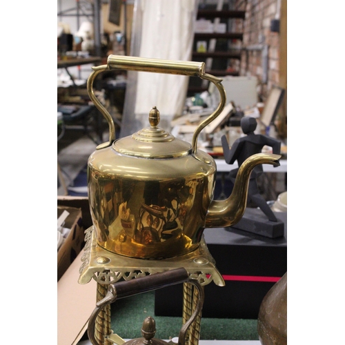 950 - A LARGE BRASS KETTLE ON A TRIVET PLUS A LARGE COPPER KETTLE BOTH WITH ACORN FINIALS