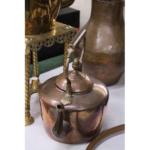 950 - A LARGE BRASS KETTLE ON A TRIVET PLUS A LARGE COPPER KETTLE BOTH WITH ACORN FINIALS