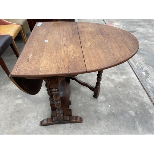 2939 - AN OVAL OAK GEORGE III STYLE GATE LEG TABLE ON TURNED LEGS, 57.5