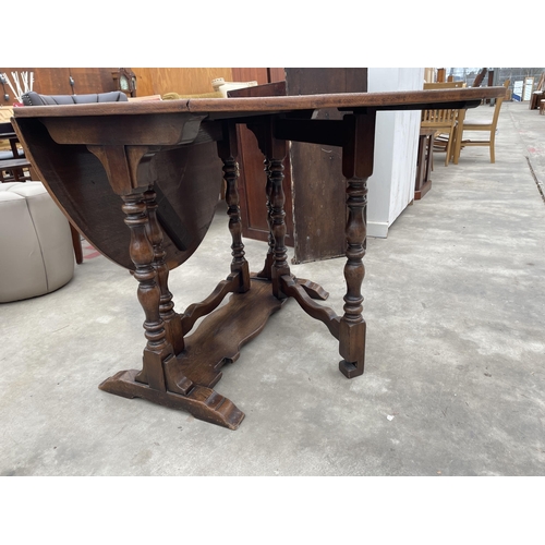 2939 - AN OVAL OAK GEORGE III STYLE GATE LEG TABLE ON TURNED LEGS, 57.5