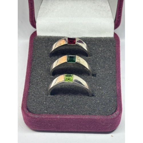 506 - A SET OF THREE SILVER RINGS WITH COLOURED STONES IN A PRESENTATION BOX