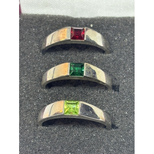 506 - A SET OF THREE SILVER RINGS WITH COLOURED STONES IN A PRESENTATION BOX