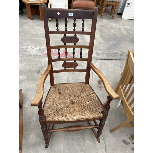 2945 - A VICTORIAN ELM ROCKING CHAIR WITH TURNED UPRIGHTS AND RUSH SEAT