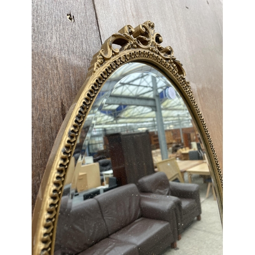 2976 - AN OVAL GILT FRAMED BEVEL EDGE WALL MIRROR WITH FOLIATE FRAME, 26