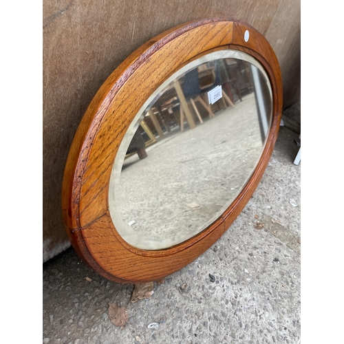 2980 - A MID 20TH CENTURY OVAL OAK BEVEL EDGE WALL MIRROR, 27