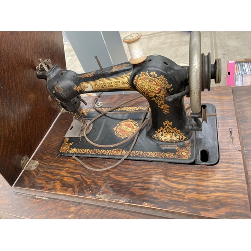 1916 - A VINTAGE JONES TREADLE SEWING MACHINE WITH CAST IRON BASE AND CABINET