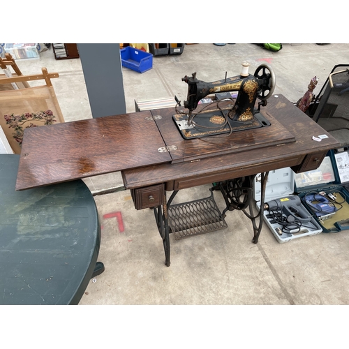 1916 - A VINTAGE JONES TREADLE SEWING MACHINE WITH CAST IRON BASE AND CABINET