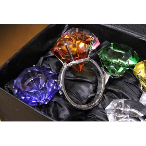 1169 - A BOXED SET OF SIX NAPKIN RINGS WITH LARGE STONES TO LOOK LIKE SOLITAIRE RINGS