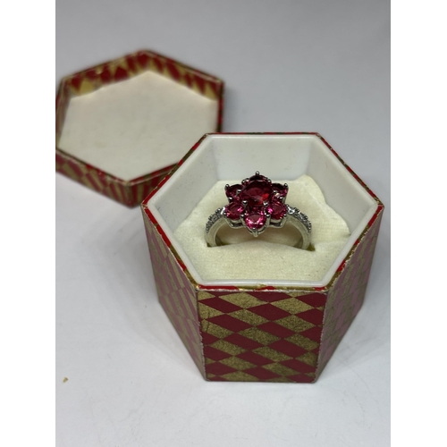 534 - A SILVER RED STONE CLUSTER DRESS RING IN A PRESENTATION BOX