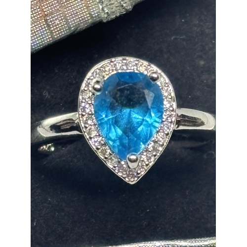 621 - A MARKED 925 SILVER RING WITH A TEARDROP BLUE TOPAZ STONE IN A PRESENTATION BOX