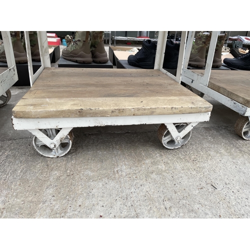 1798 - AN INDUSTRIAL STYLE SHELVING UNIT WITH PLANK SHELVES AND RAILWAY TROLLEY WHEEL BASE