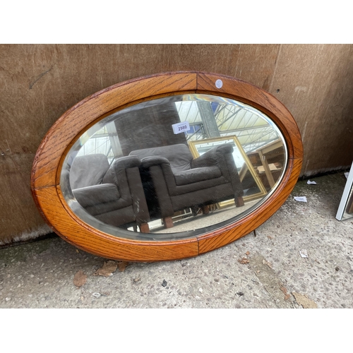 2980 - A MID 20TH CENTURY OVAL OAK BEVEL EDGE WALL MIRROR, 27