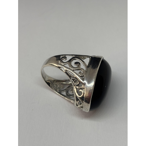 532 - A HEAVY SILVER SIGNET RING WITH LARGE OVAL DARK STONE