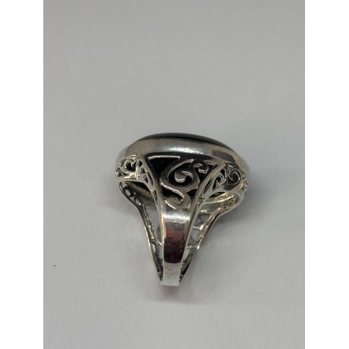 532 - A HEAVY SILVER SIGNET RING WITH LARGE OVAL DARK STONE