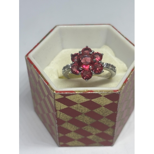 601 - A SILVER AND PINK STONE CLUSTER DRESS RING IN A PRESENTATION BOX