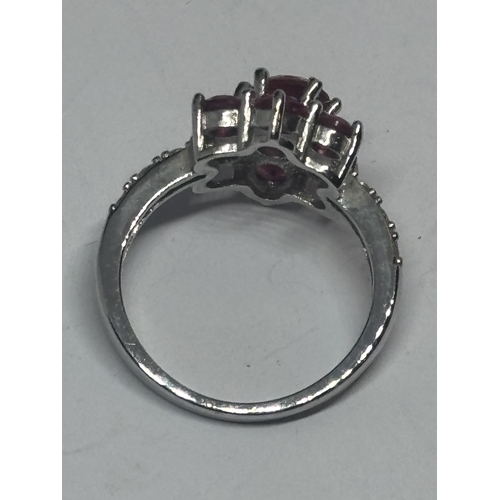 601 - A SILVER AND PINK STONE CLUSTER DRESS RING IN A PRESENTATION BOX