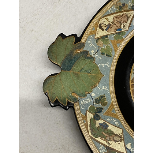 328 - A LACQUERED PAPIER MACHE FOOTED PLATE WITH VINE LEAF SHAPED HANDLES IN THE JAPANESE AESTHETIC STYLE ... 