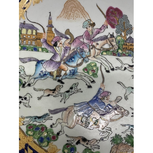 329 - A VINTAGE CHINESE QIANLONG PORCELAIN CHARGER DEPICTING A EUROPEAN HUNTING SCENE - 26 CM (D)