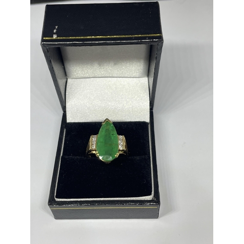 640 - A MARKED 14 CARAT GOLD RING WITH LARGE TEARDROP SHAPED EMERALD WITH DIAMONDS TO EACH SIDE SIZE N/O I... 