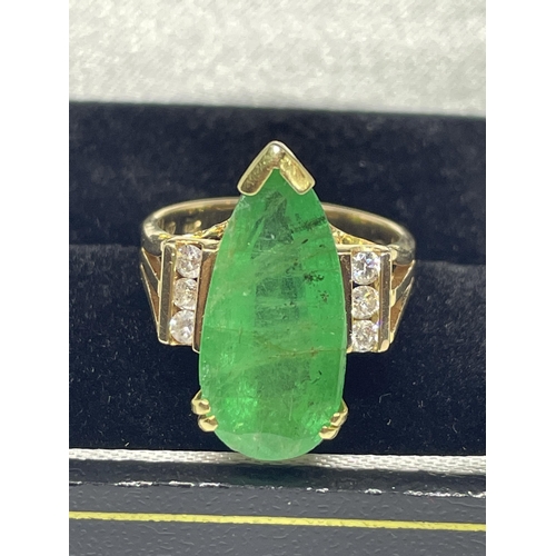 640 - A MARKED 14 CARAT GOLD RING WITH LARGE TEARDROP SHAPED EMERALD WITH DIAMONDS TO EACH SIDE SIZE N/O I... 