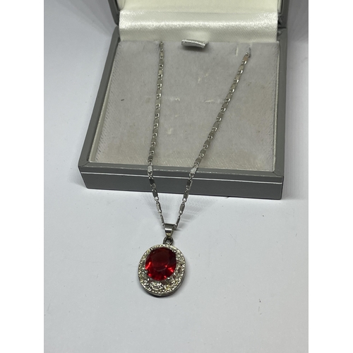 652 - A MARKED SILVER NECKLACE WITH RED STONE PENDANT IN A PRESENTATION BOX