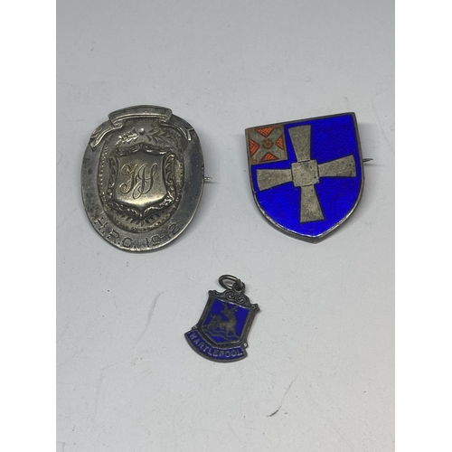 676 - THREE MARKED SILVER ITEMS TO INCLUDE TWO HALLMARKED BIRMINGHAM BADGES ONE ENAMELED AND A CHARM