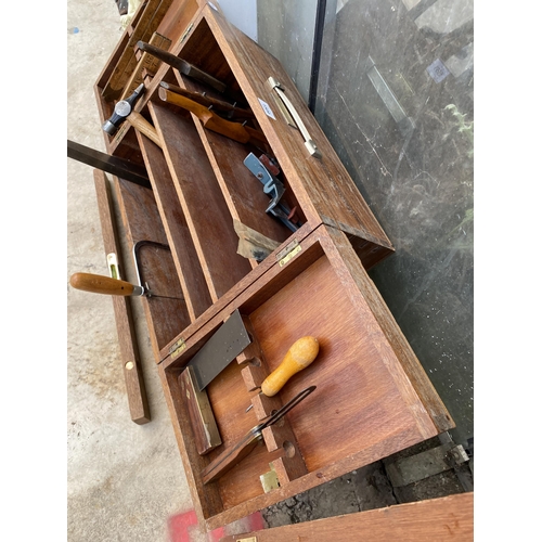 1509 - A TEAK JOINERS CHEST WITH AN ASSORTMENT OF TOOLS TO INCLUDE WOOD PLANES, A HAMMER AND A SAW ETC