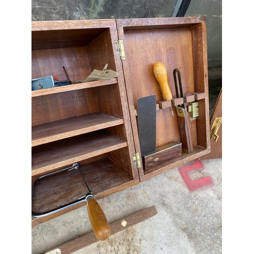 1509 - A TEAK JOINERS CHEST WITH AN ASSORTMENT OF TOOLS TO INCLUDE WOOD PLANES, A HAMMER AND A SAW ETC