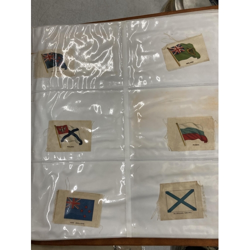 245 - A COLLECTION OF VINTAGE SILK FLAGS IN AN ALBUM