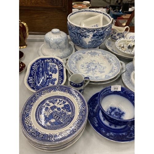 252 - A LARGE QUANTITY OF VINTAGE BLUE AND WHITE POTTERY TO INCLUDE SERVING BOWLS, A LIDDED TUREEN, PLATTE... 