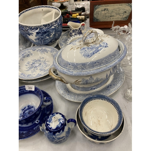 252 - A LARGE QUANTITY OF VINTAGE BLUE AND WHITE POTTERY TO INCLUDE SERVING BOWLS, A LIDDED TUREEN, PLATTE... 