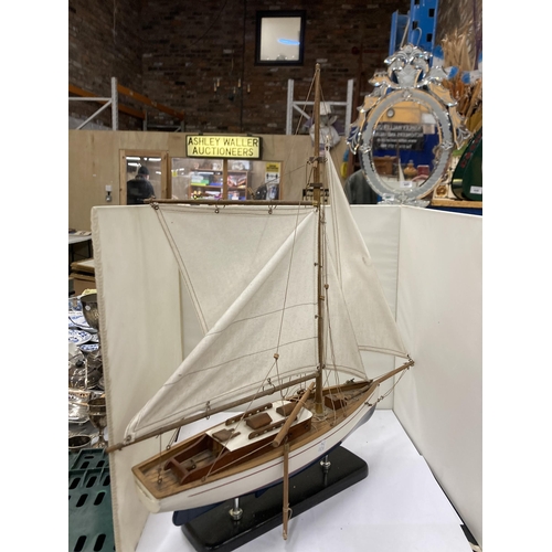 294 - A SMALL WOODEN MODEL OF A SAILING YACHT