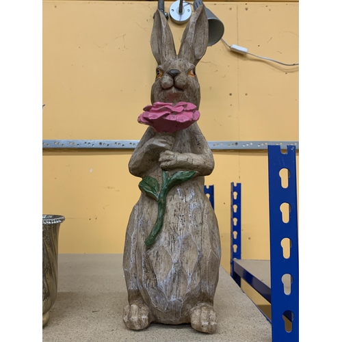 412 - A WOODEN MODEL OF A RABBIT HOLDING A FLOWER, HEIGHT 46CM