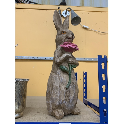 412 - A WOODEN MODEL OF A RABBIT HOLDING A FLOWER, HEIGHT 46CM