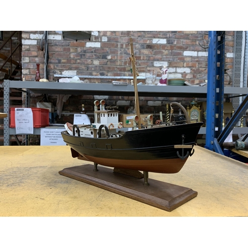 422 - A WOODEN MODEL OF A FISHING BOAT ON A WOODEN STAND WITH NON MARKED PLAQUE