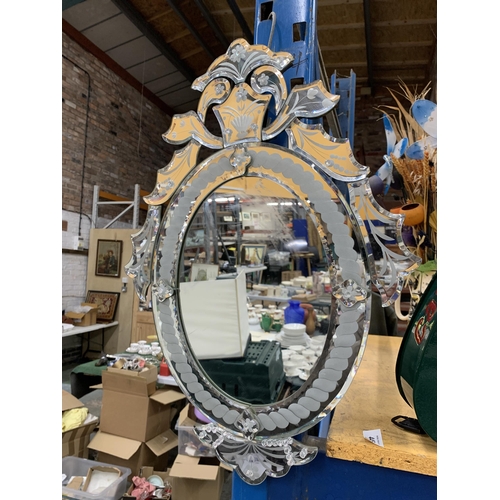 445 - AN ORNATE OVAL WALL MIRROR WITH BEVEL EDGE AND DECORATIVE BEADS