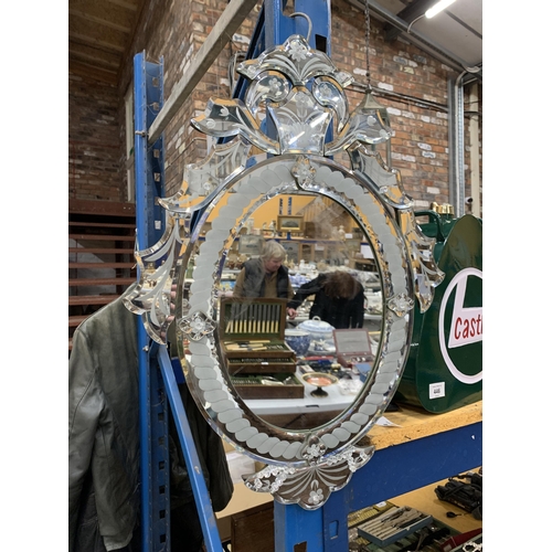 445 - AN ORNATE OVAL WALL MIRROR WITH BEVEL EDGE AND DECORATIVE BEADS