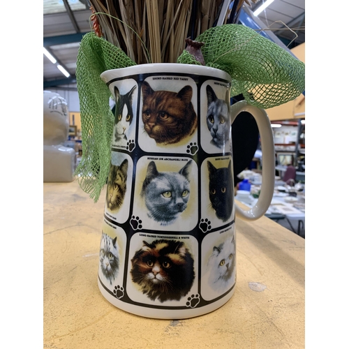 495 - A CERAMIC JUG WITH CAT PICTURES CONTAINING DRIED FLOWERS AND GRASSES