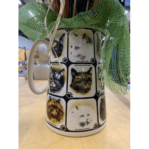 495 - A CERAMIC JUG WITH CAT PICTURES CONTAINING DRIED FLOWERS AND GRASSES