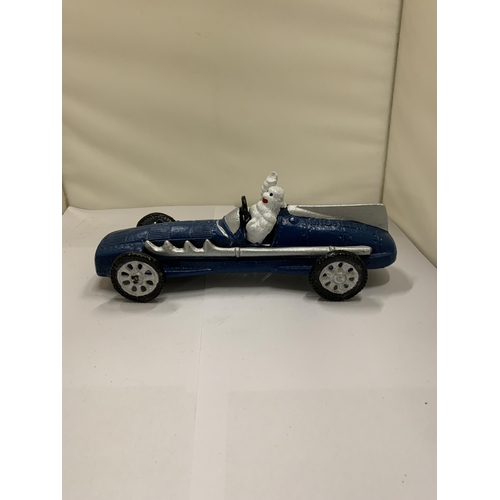 822 - A CAST MICHELIN MAN IN A BLUE RACING CAR, LENGTH 26CM