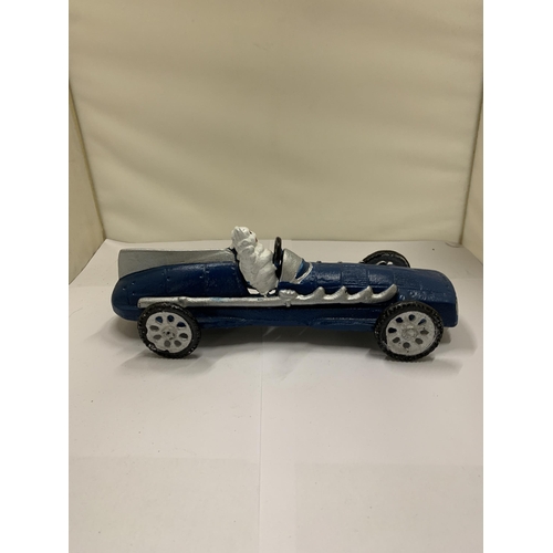 822 - A CAST MICHELIN MAN IN A BLUE RACING CAR, LENGTH 26CM