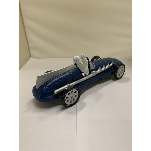 822 - A CAST MICHELIN MAN IN A BLUE RACING CAR, LENGTH 26CM