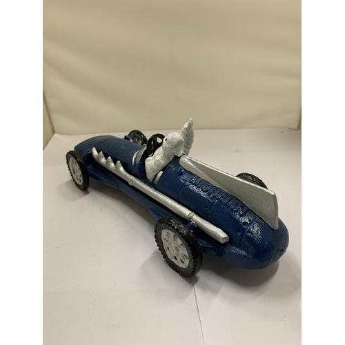 822 - A CAST MICHELIN MAN IN A BLUE RACING CAR, LENGTH 26CM