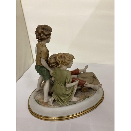 824 - A CAPODIMONTE STYLE FIGURE GROUP OF CHILDREN PLAYING ON A CART