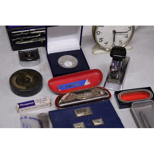 880 - A MIXED LOT TO INCLUDE PERPETUAL CALENDARS, TWO CLOCKS, A HARMONICA, ETC